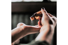 Putting an essential oil in the palm of the hand.